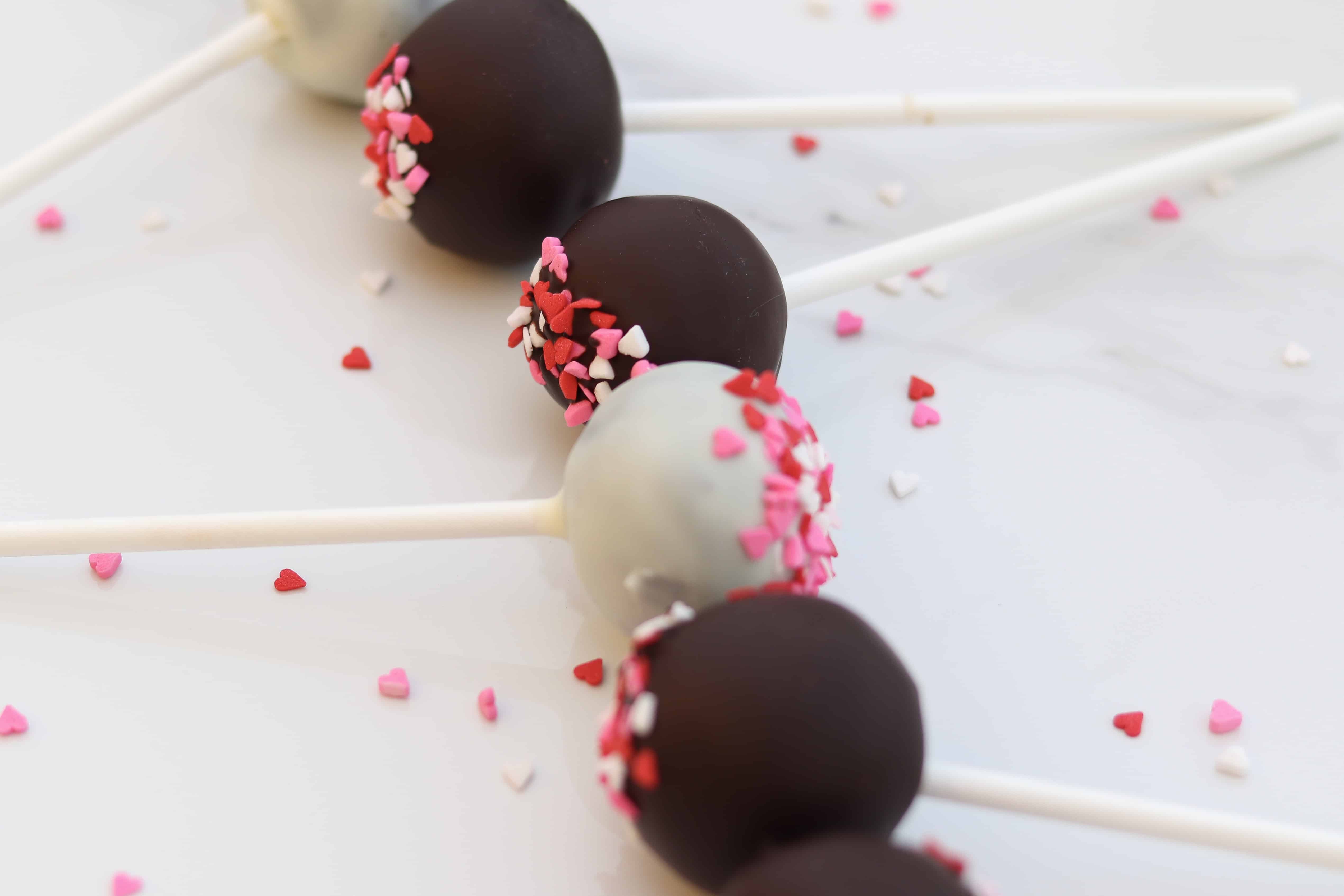 Vertical row of cake pops with heart sprinkles