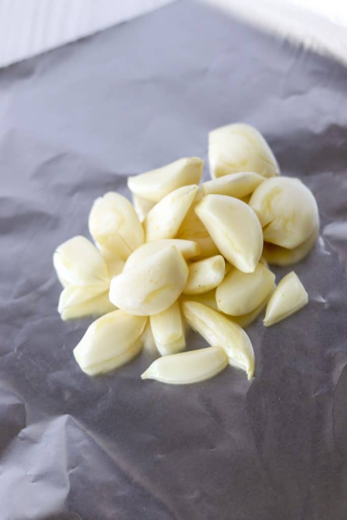 raw garlic cloves peeled and placed on a piece of aluminum foil