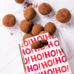 Chocolate truffles spilling out of a holiday gift box.
