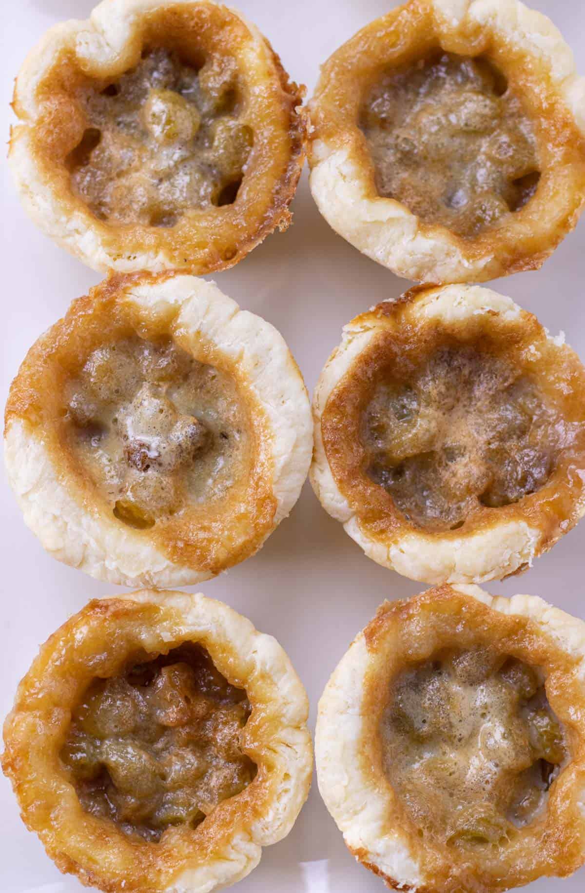 Butter tarts on a white serving tray.