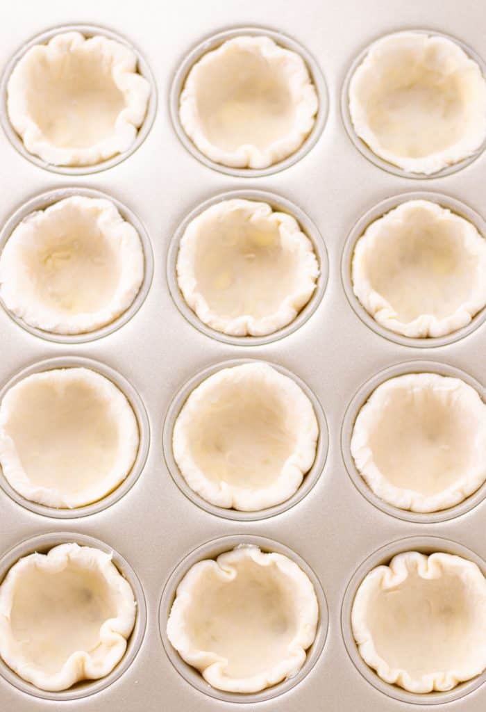 sweet dough pie crust portioned out into the muffin tin
