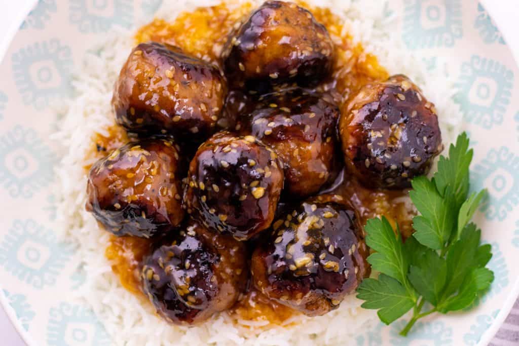 serving the apricot sesame turkey meatballs over rice
