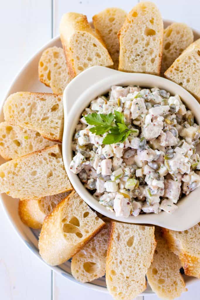 chicken salad served with slices of baguette bread