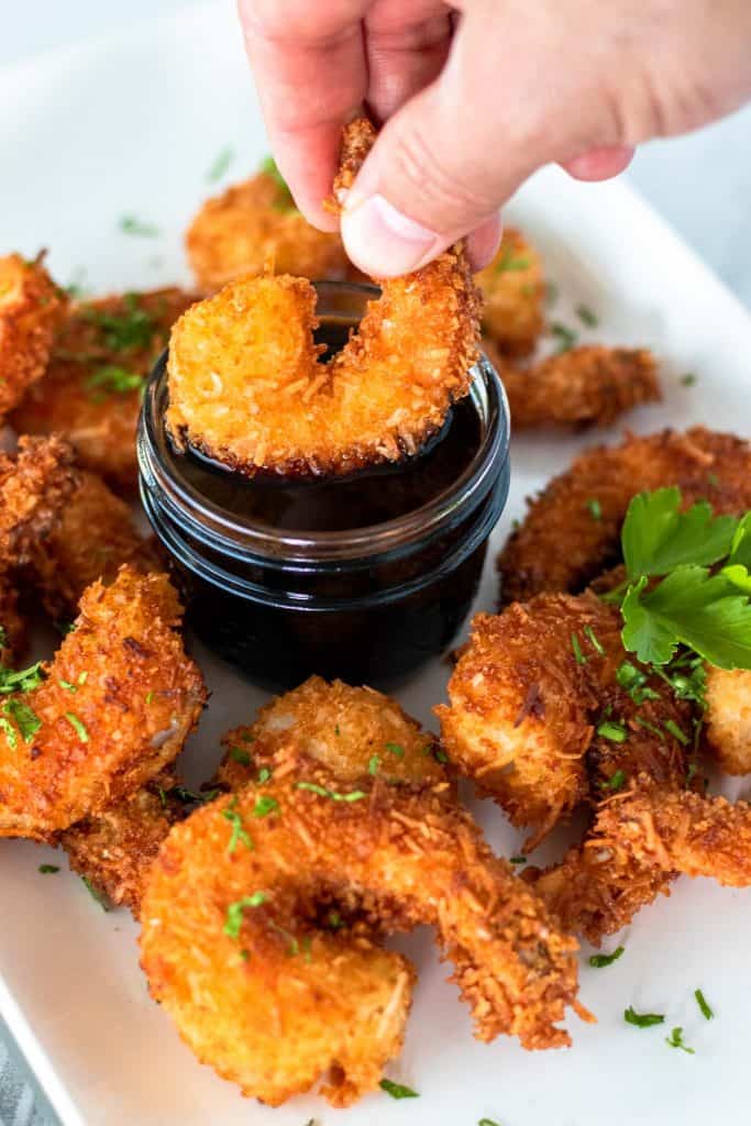 Dipping a coconut shrimp into the honey soy dipping sauce
