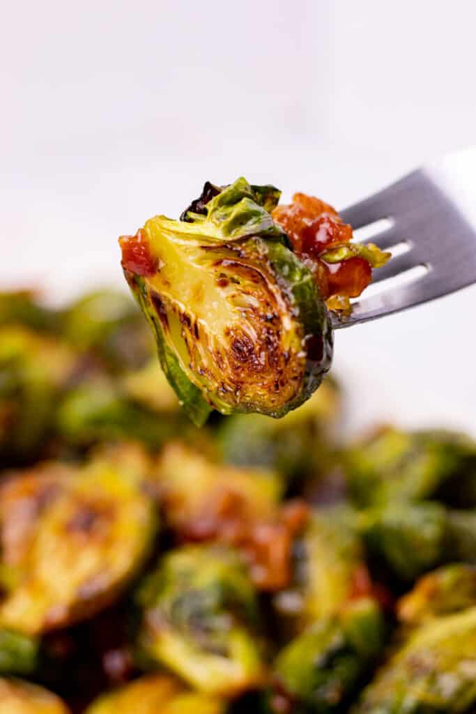 a brussel sprout with spicy bacon jam on a fork