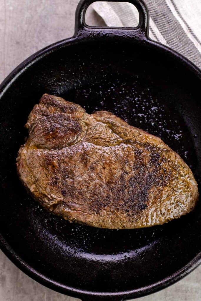 the steak, grilled to perfection in a cast iron pan