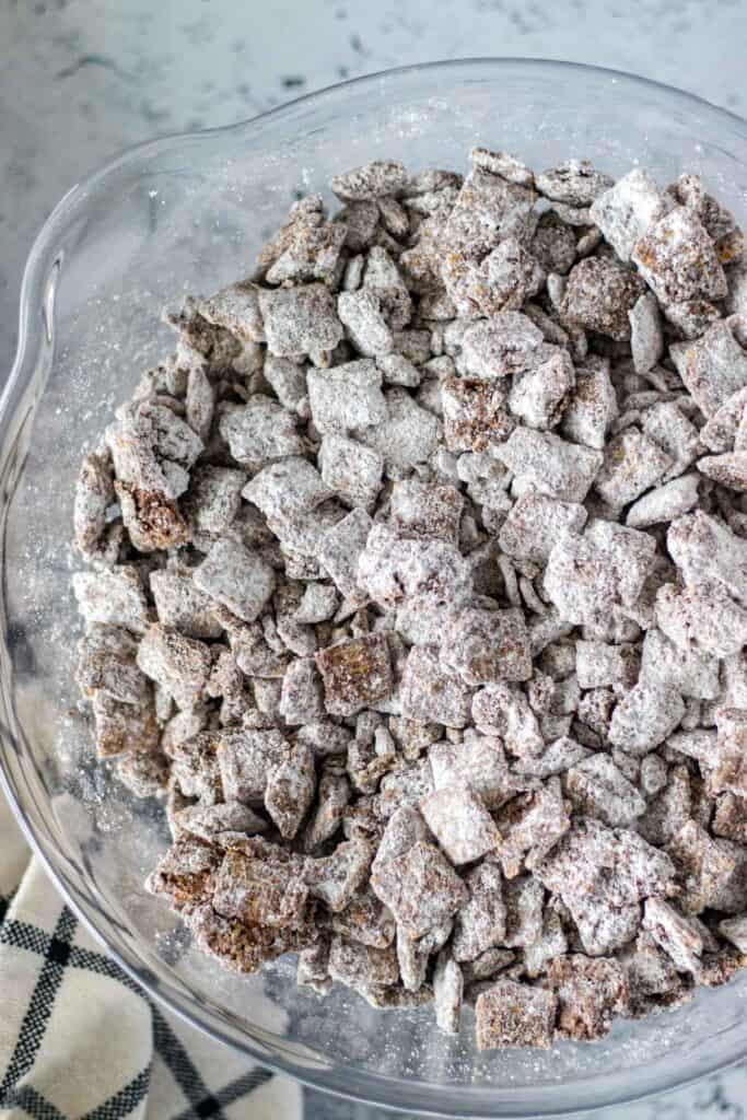 tossing the chocolate chex cereal in powdered sugar