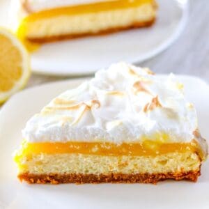 a single slice of lemon meringue cheesecake on a white plate