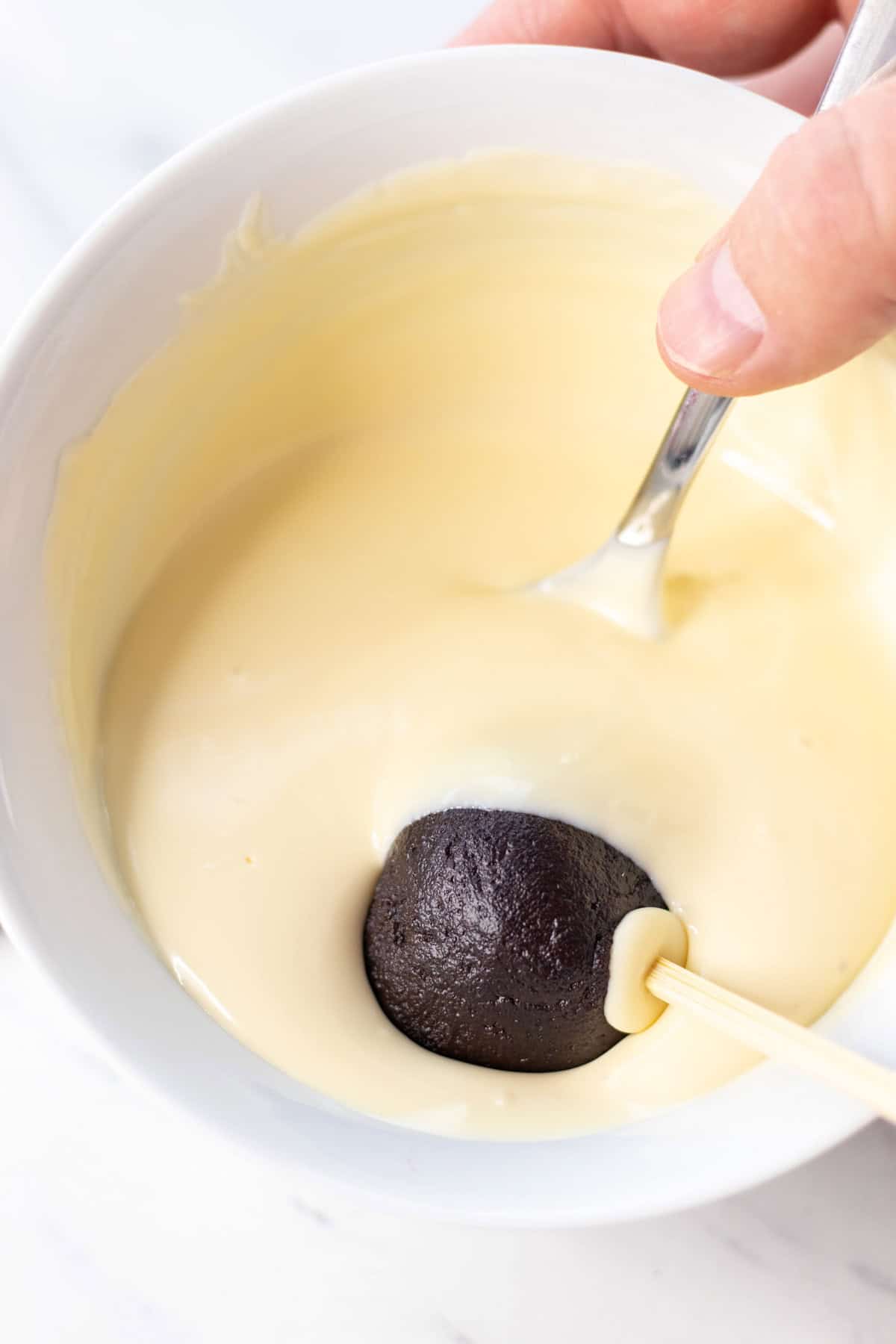 Dipping the cake balls in the melted candy melts.