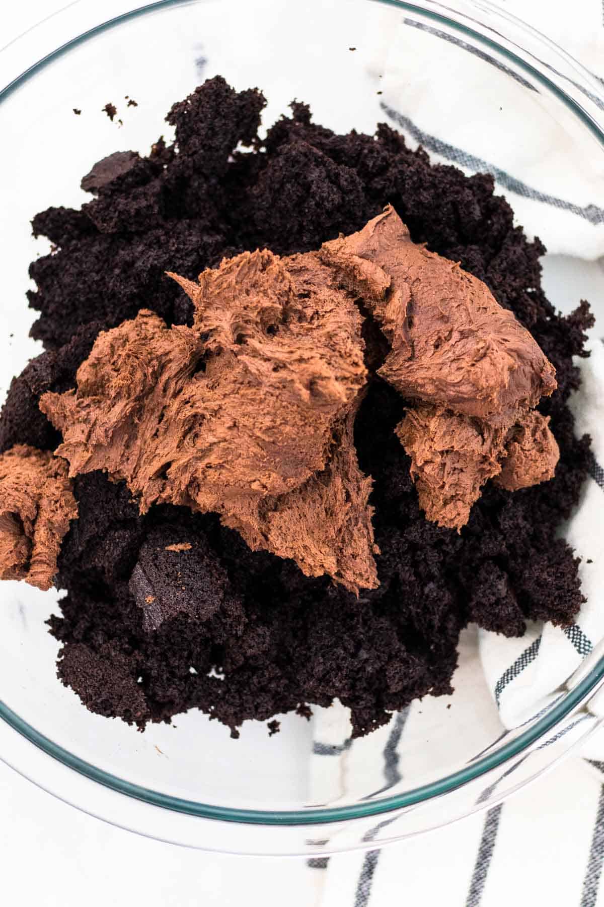 Adding the chocolate buttercream on top of the crumbled cake.