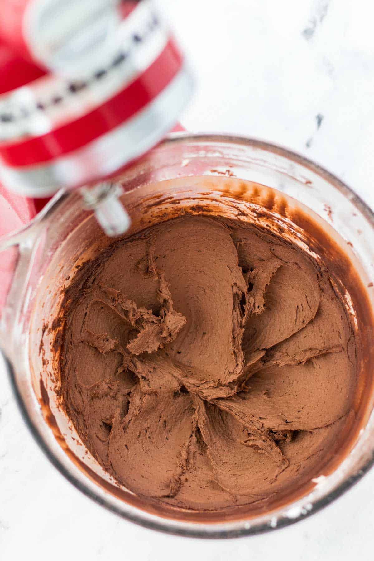 Chocolate buttercream mixed up in the bowl of the mixer.