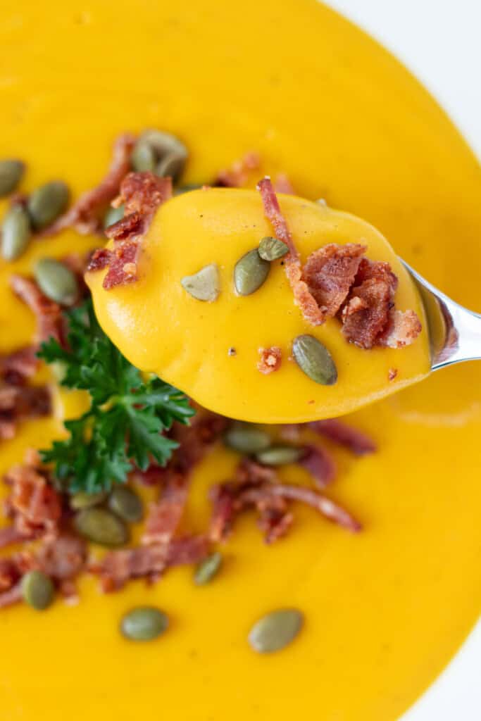 A spoonful of soup on a silver spoon.