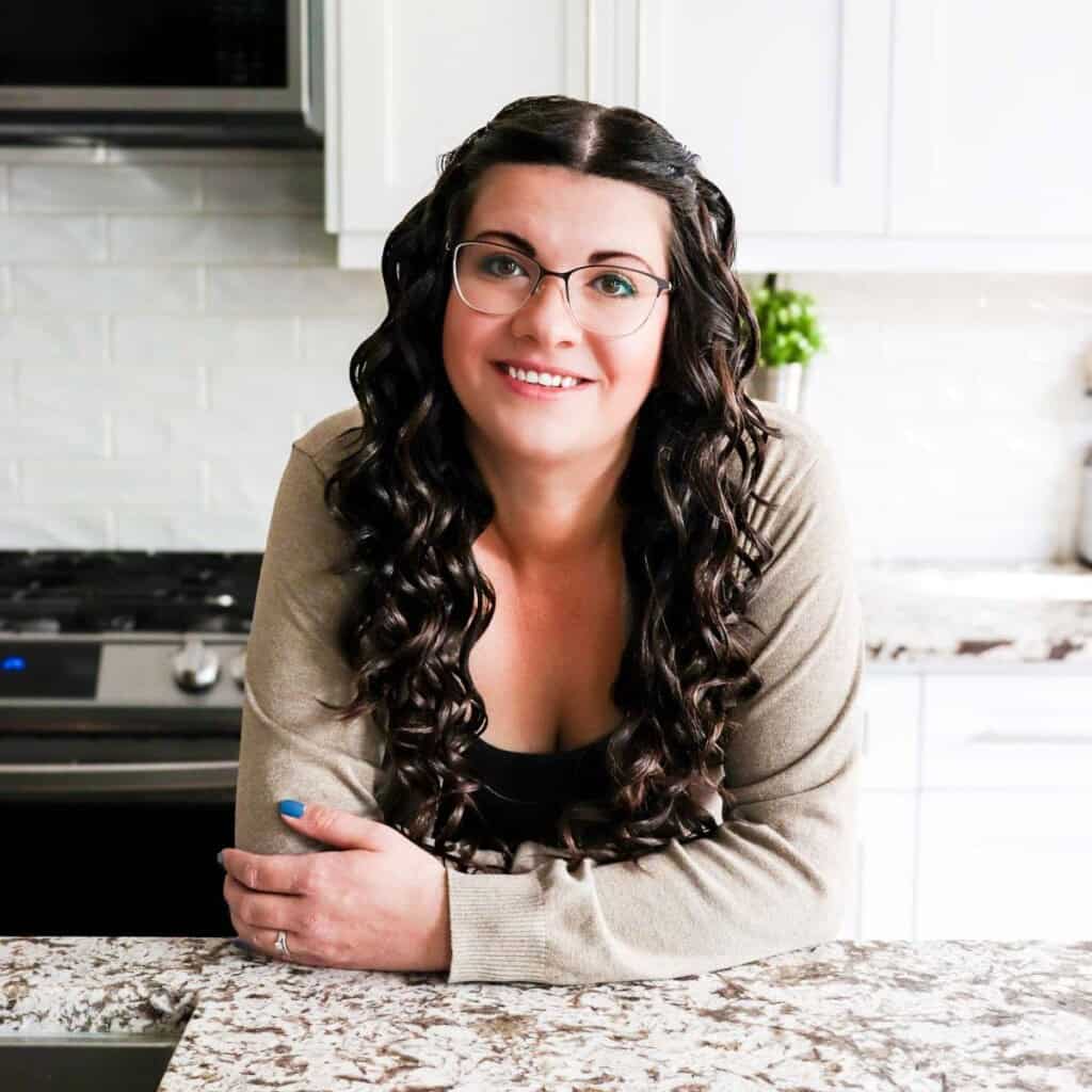 Jessica leaning on the kitchen counter smiling.