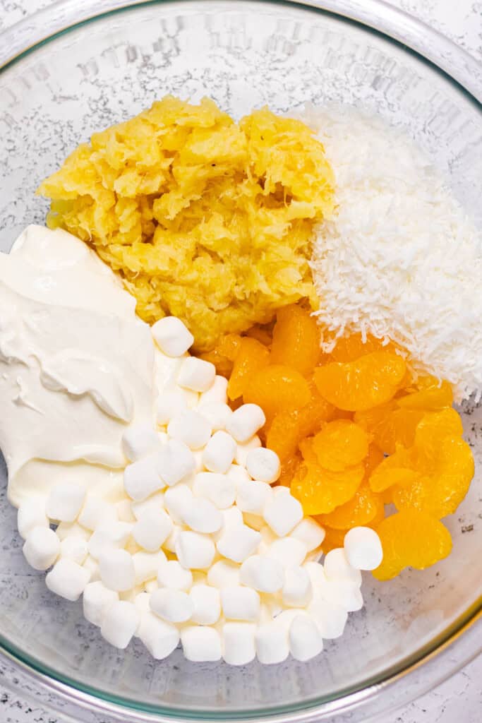 All ambrosia salad ingredients in a large glass mixing bowl.