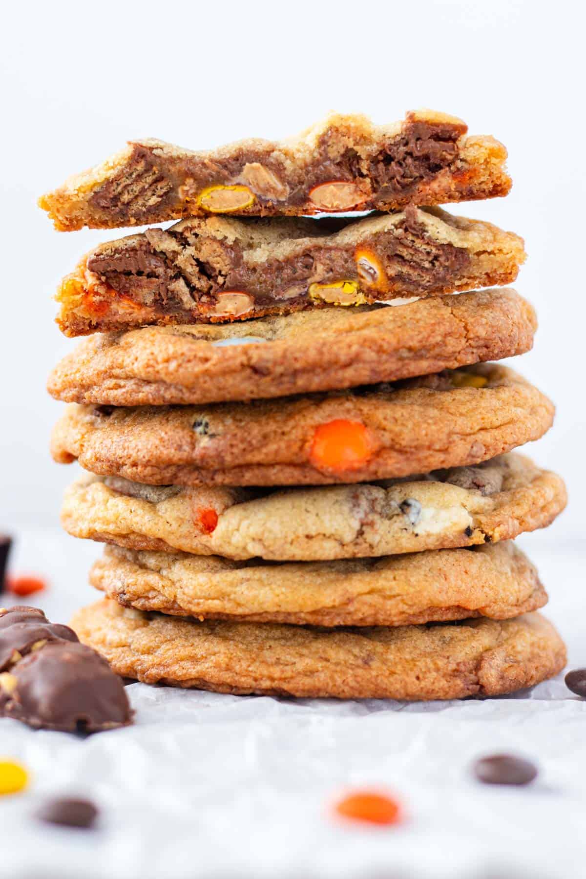 A stack of cookies with one broken in half on the top to show it exploding with halloween candy on the inside.