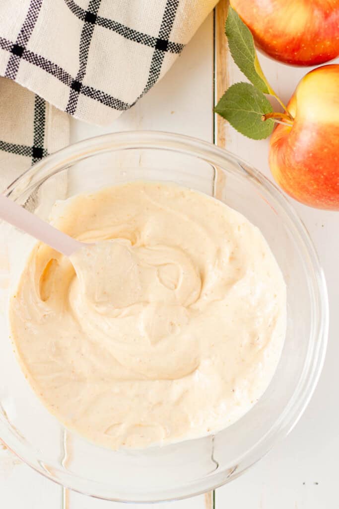 Apple dip mixed with a spatula in a glass mixing bowl.