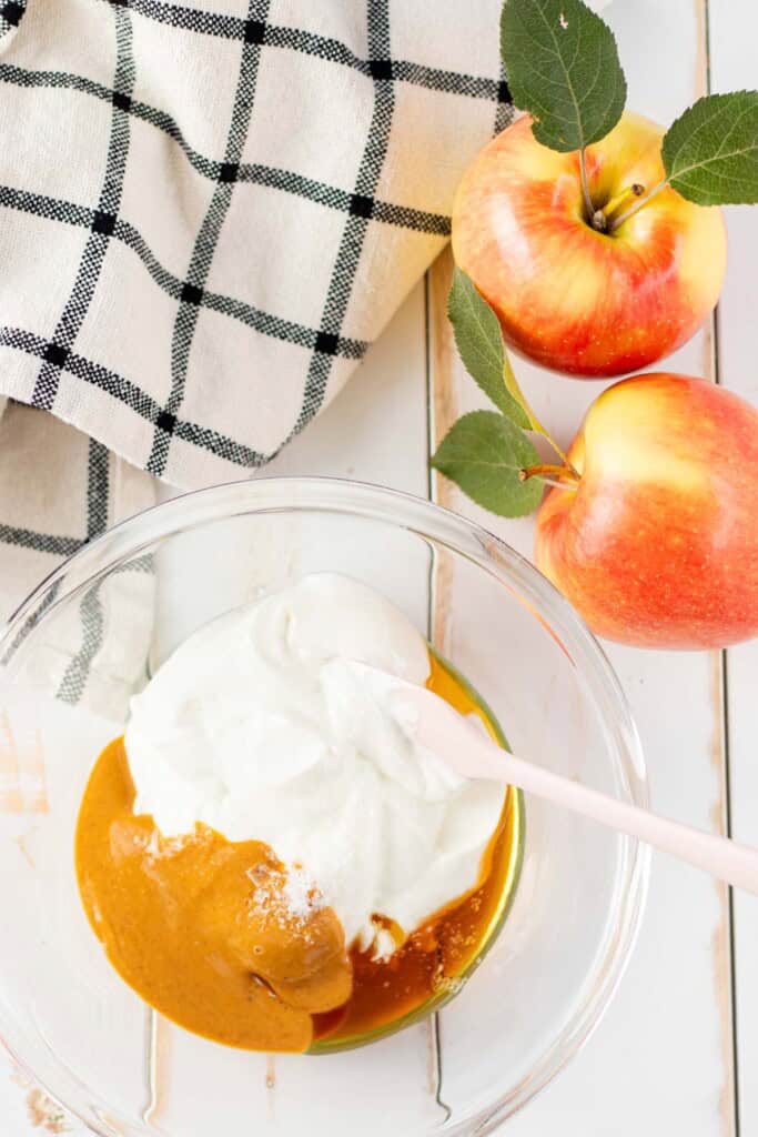 All of the apple dip ingredients in a mixing bowl with a spatula.