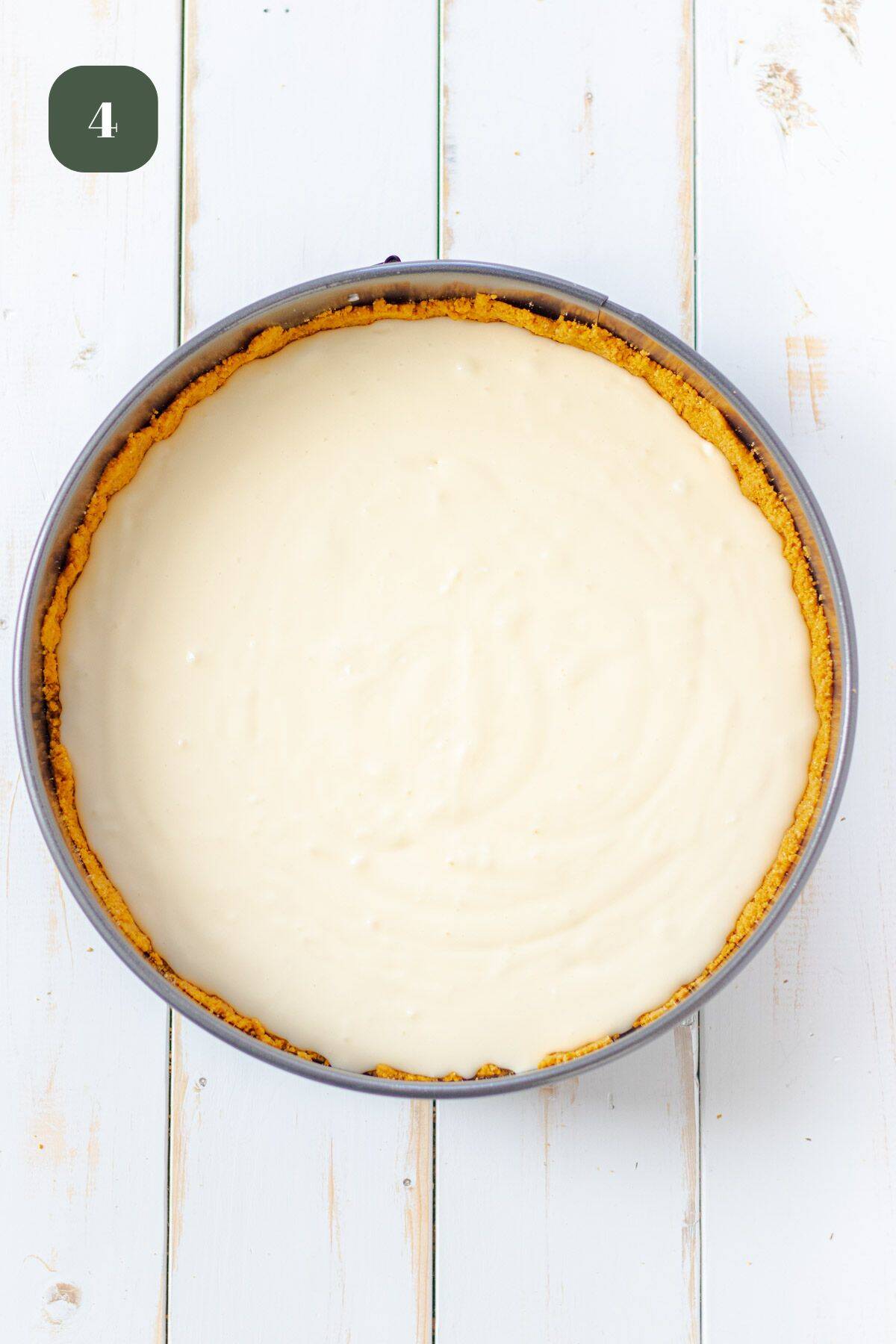 Mixed cheesecake filling poured into the graham cracker crust in a springform pan.