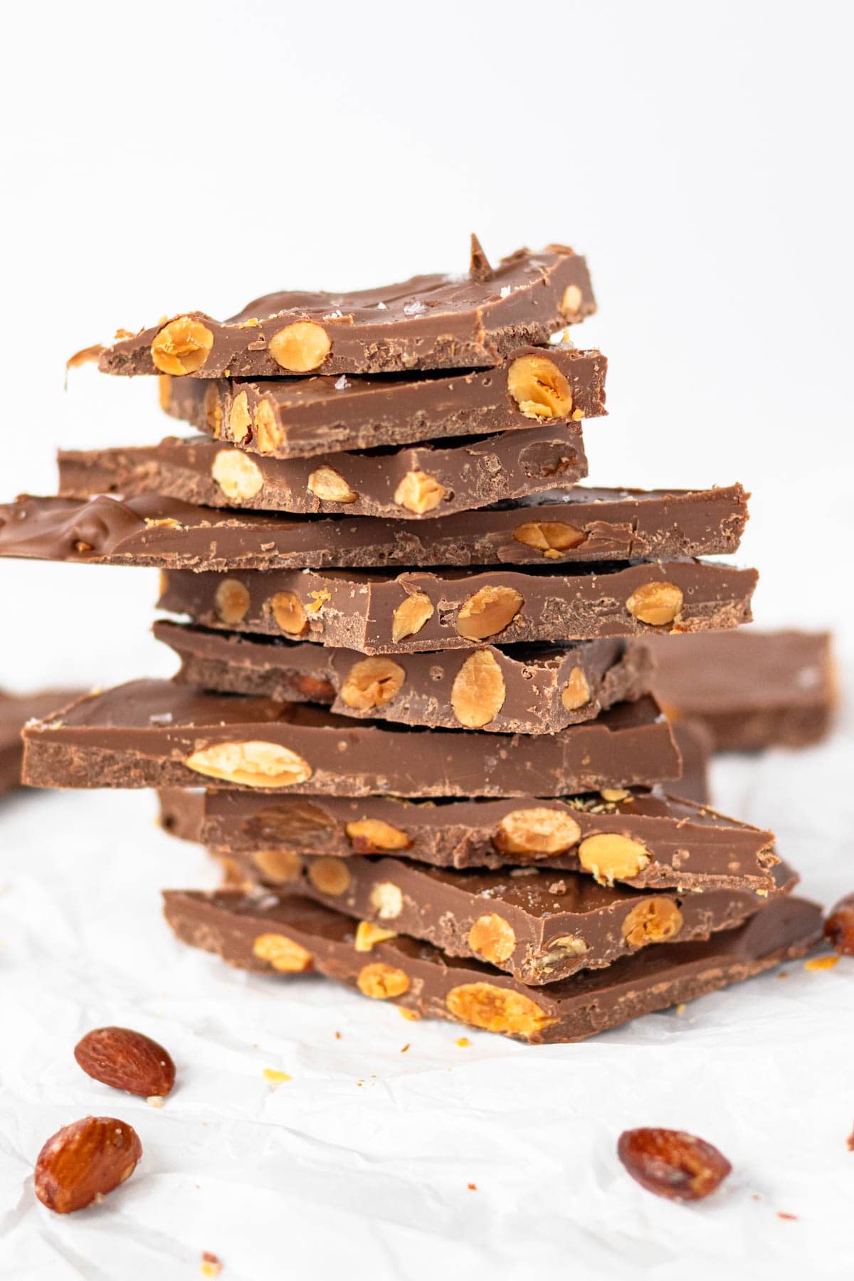 A stack of chocolate almond bark with roasted almonds.