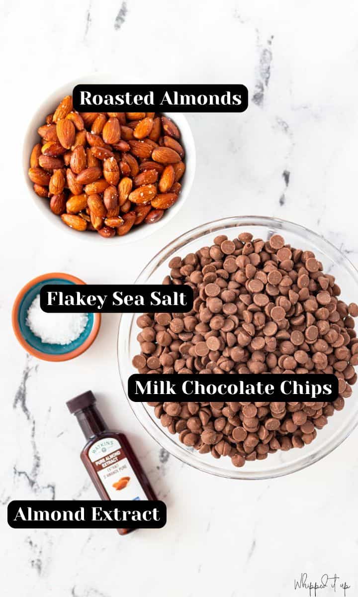 Ingredients to make milk chocolate almond bark include roasted almonds, flakey sea salt, milk chocolate chips and almond extract.