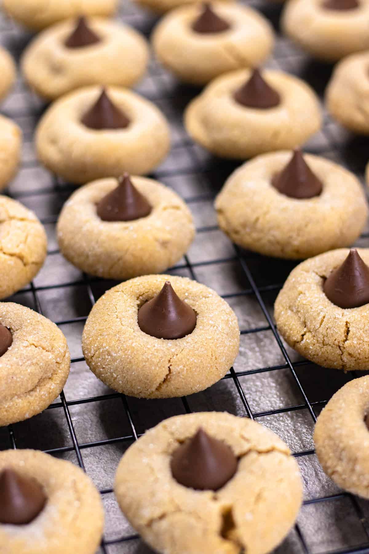 Peanut butter blossom cookies on a wire rack with a Hershey kiss on top.