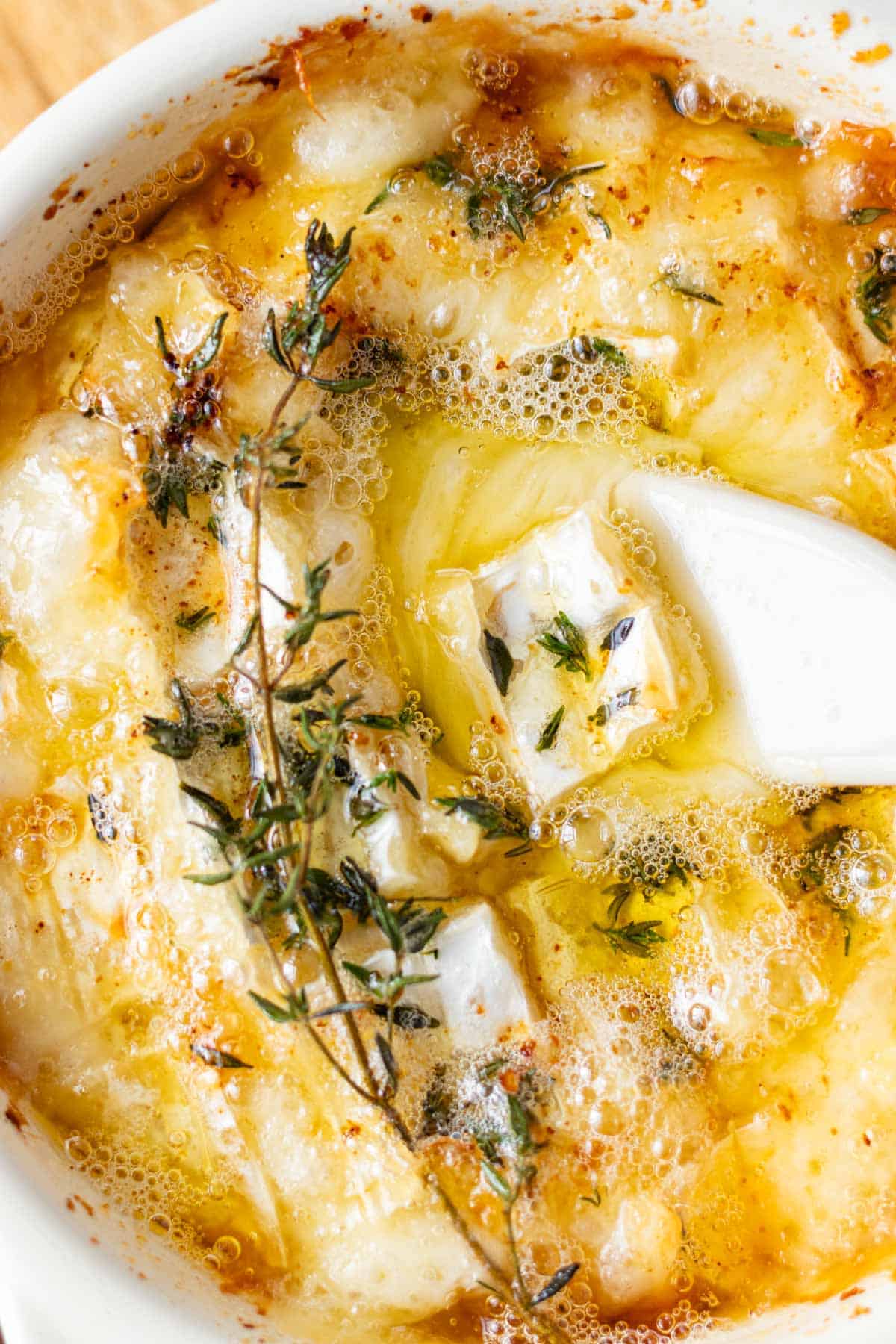 A cheese spreader placed in the centre of the wheel of baked camembert.
