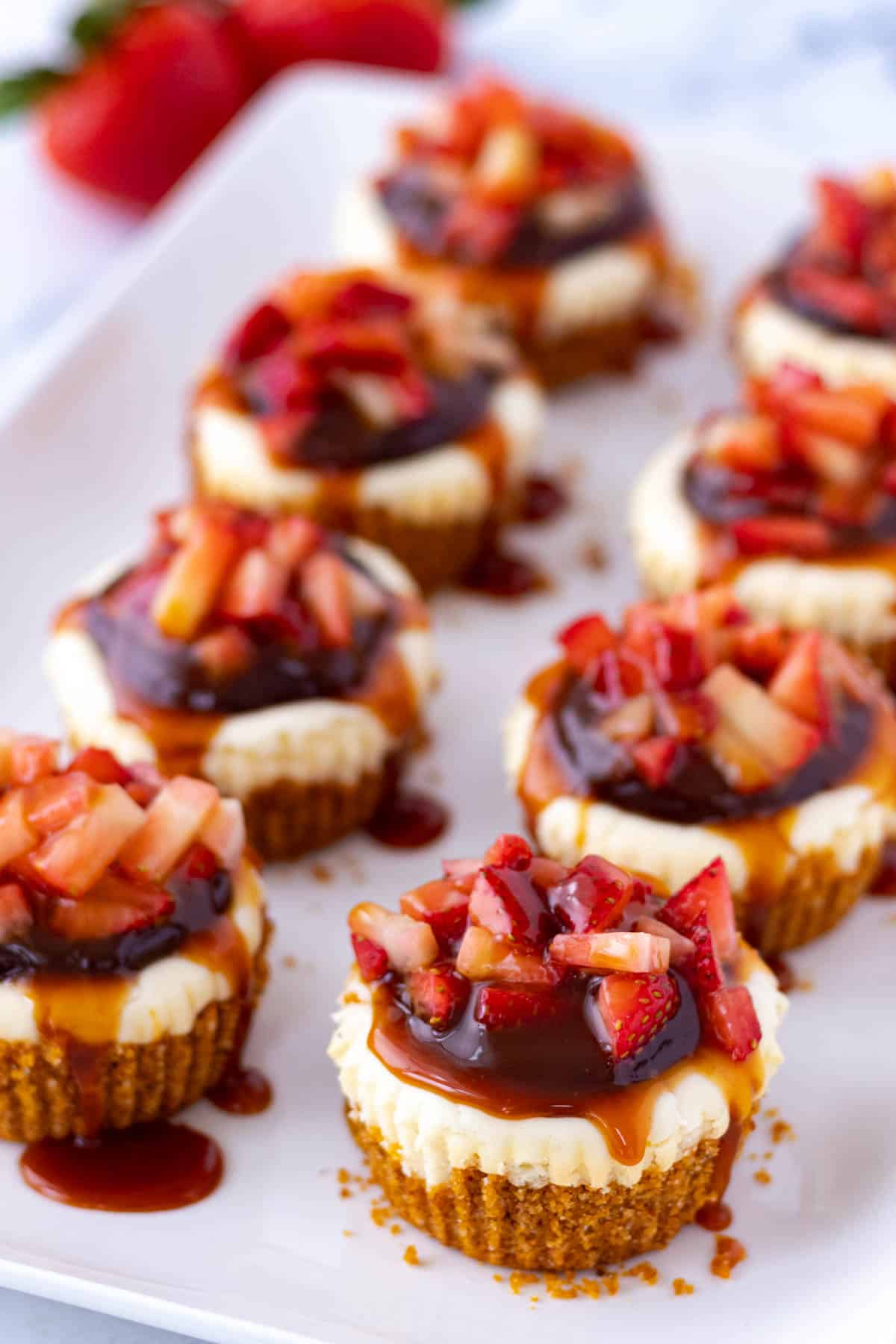 Strawberry nutella cheesecakes on a white serving platter.