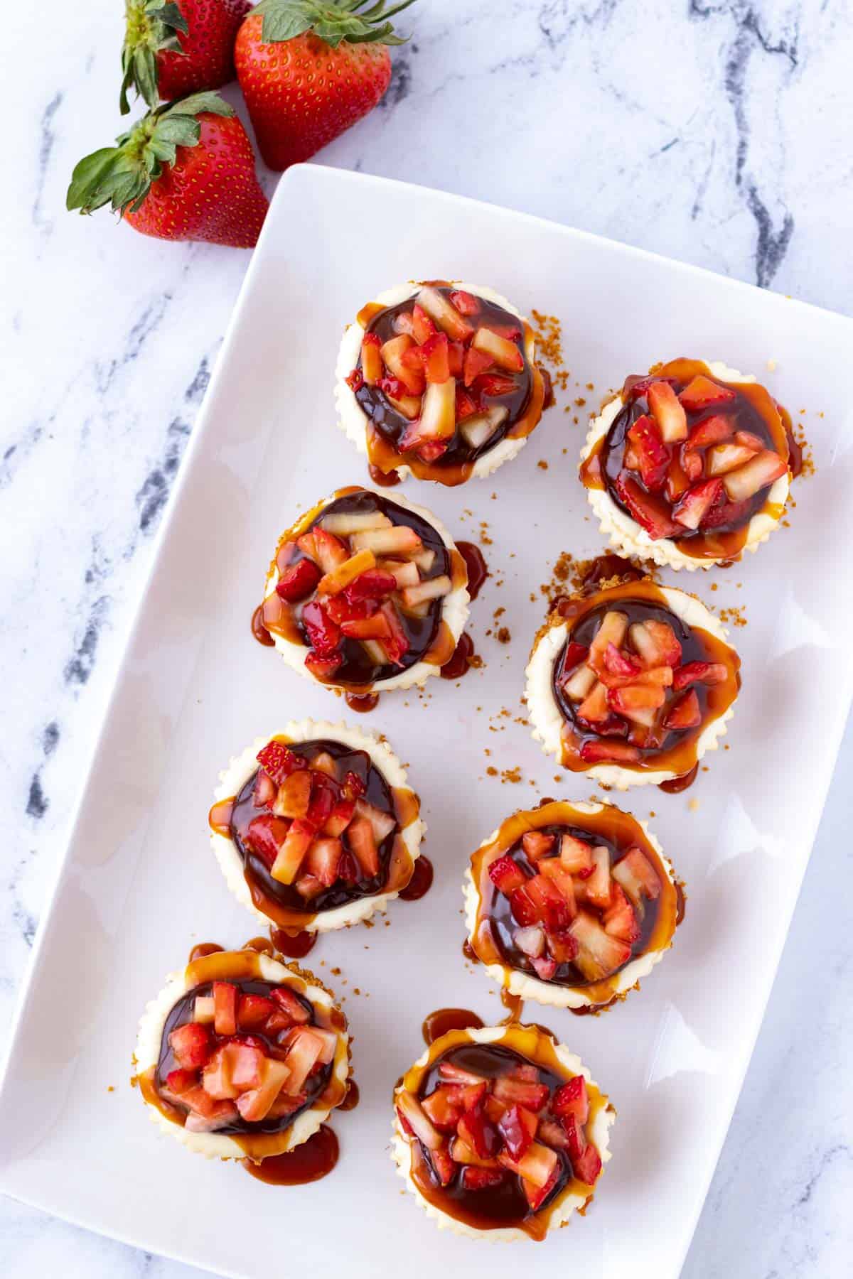 Mini cheesecakes on a serving platter.