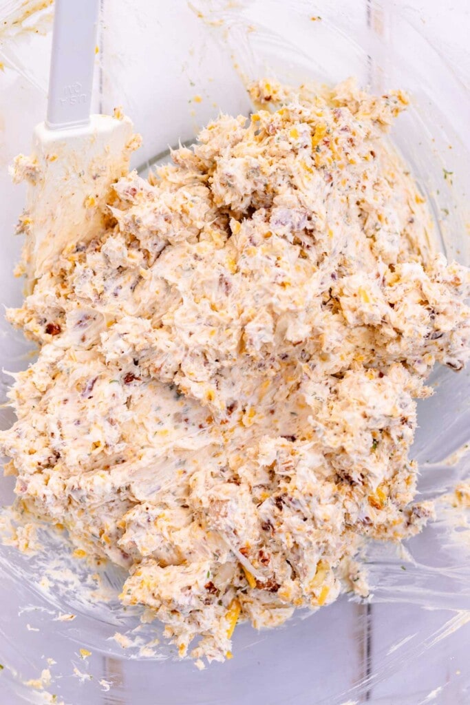 Mixing all of the ingredients for the cheese balls together in a bowl.