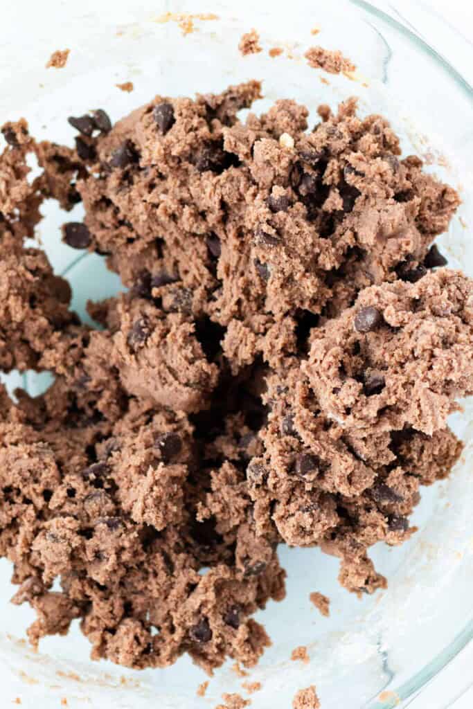 Mixing the cookie dough in a glass bowl.