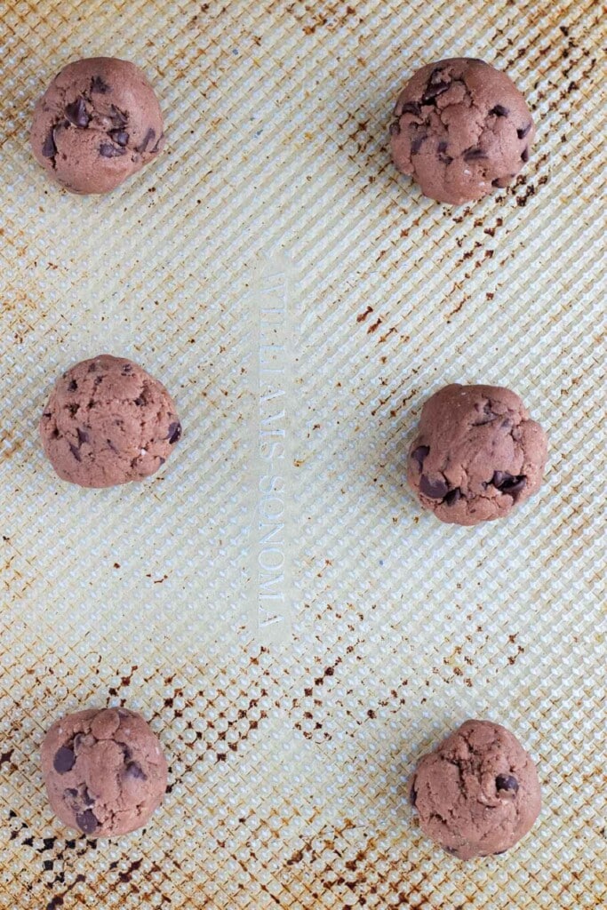 Cookie dough balls on a cookie sheet.