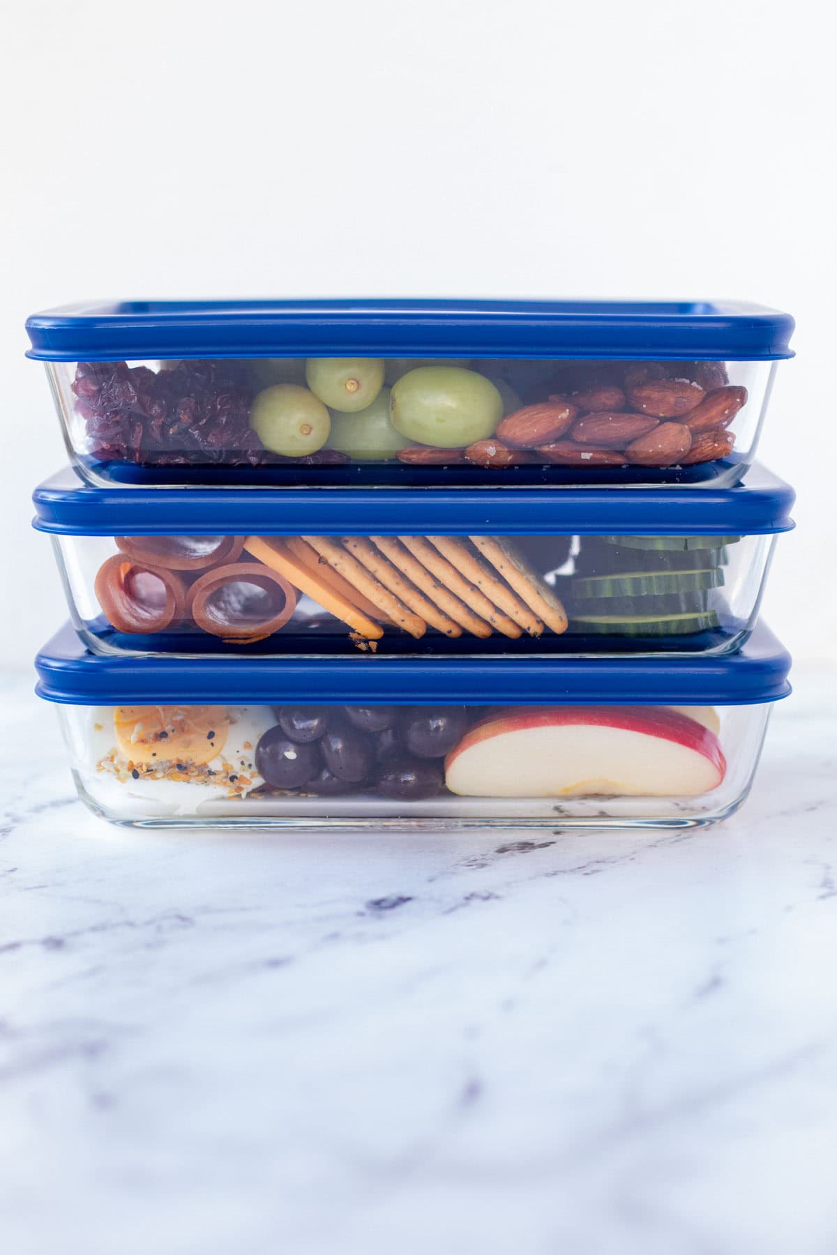 Lunchables packed up in Tupperware containers, stacked.
