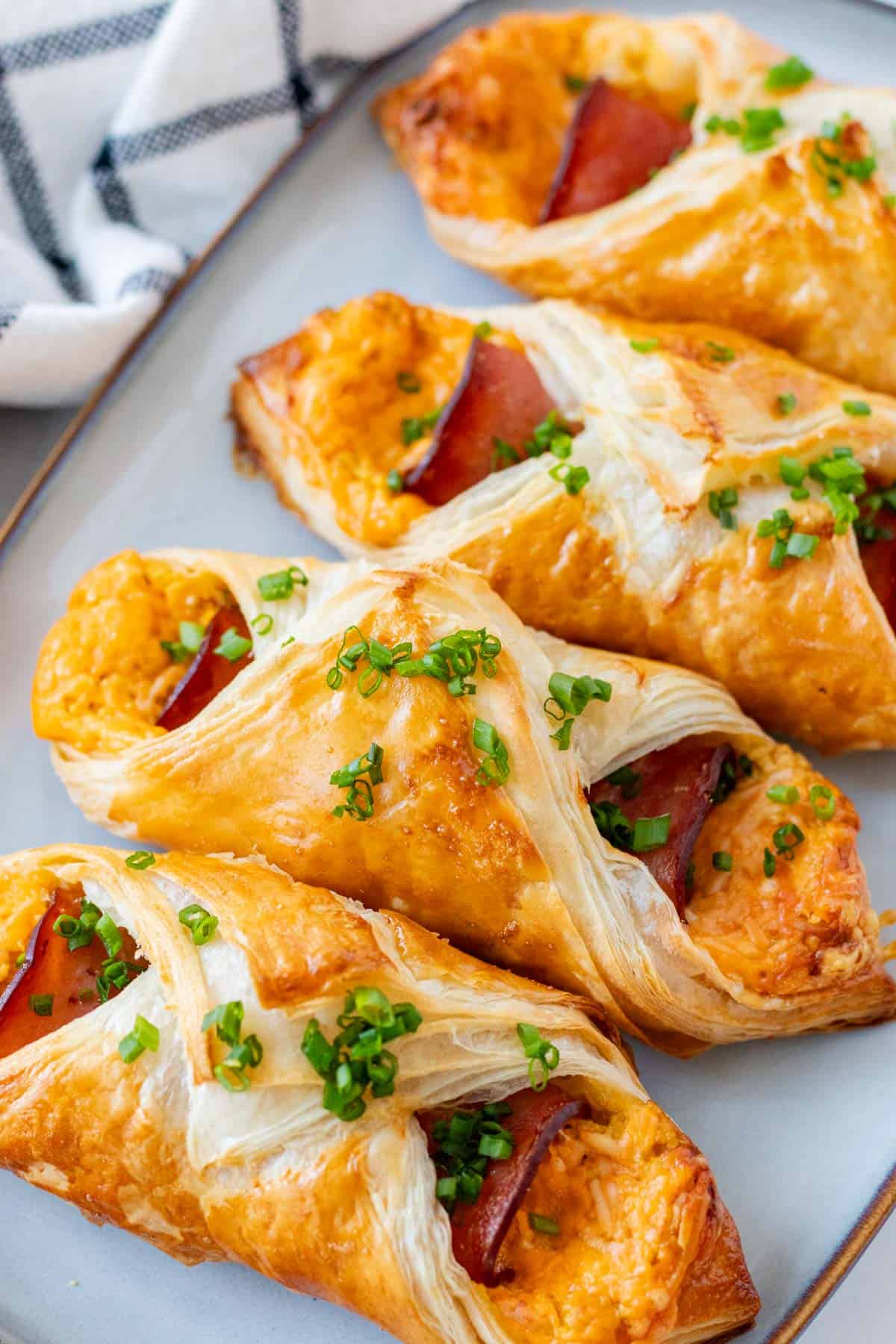 Ham and cheese croissants on a blue serving plate.