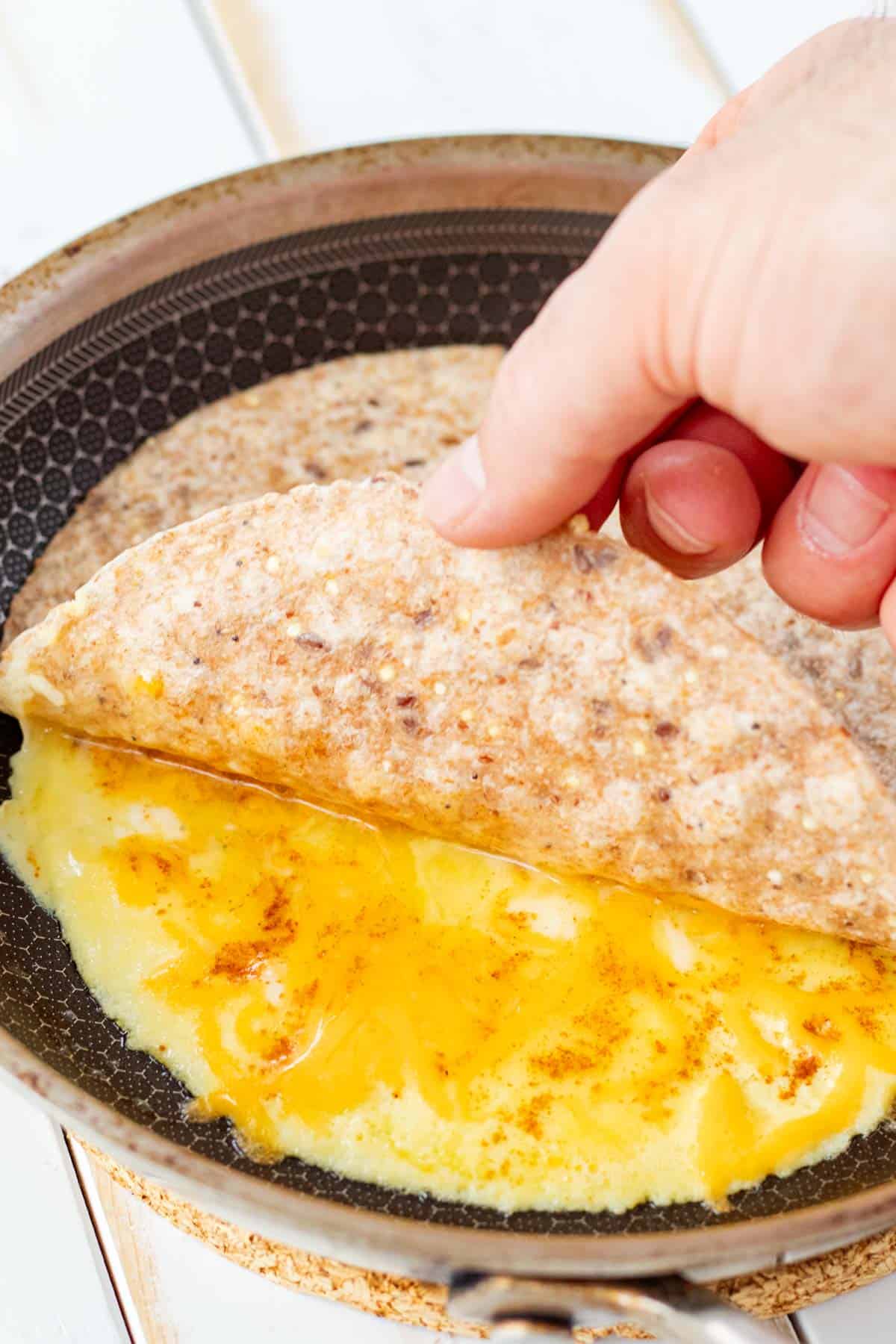 Covering the egg with a tortilla.