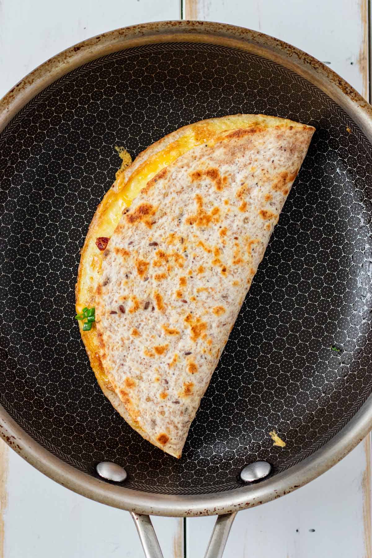 Folding the taco in the frying pan to finish crisping.