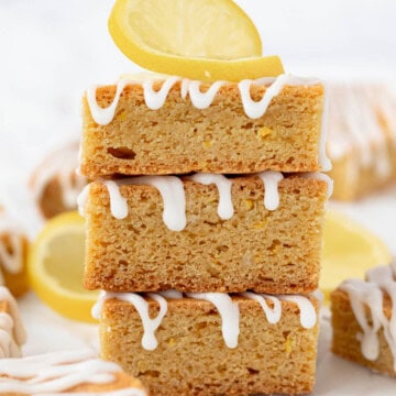 A stack of three lemon blondies with a lemon twist on top.