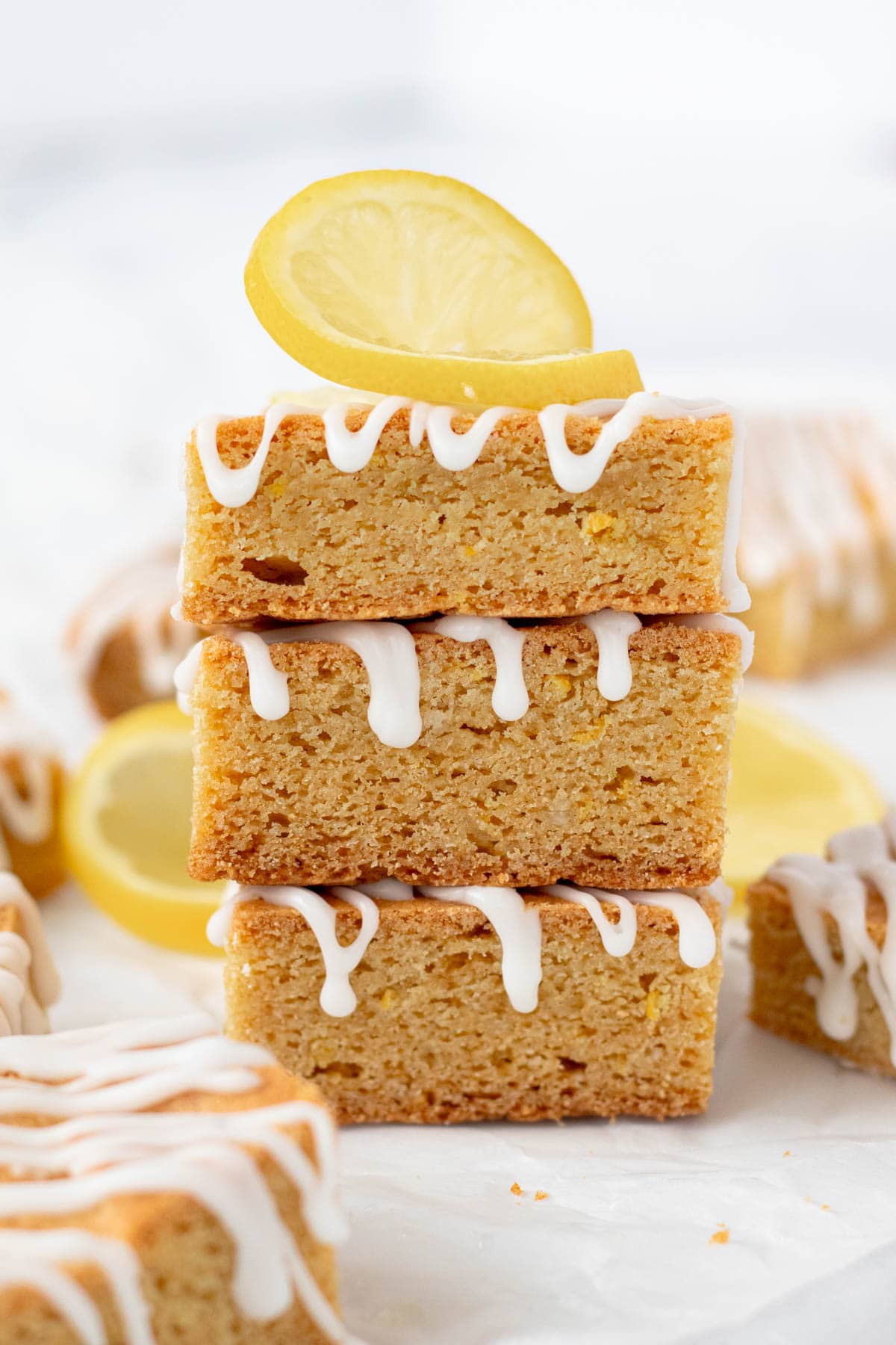 A stack of three lemon blondies with a lemon twist on top.