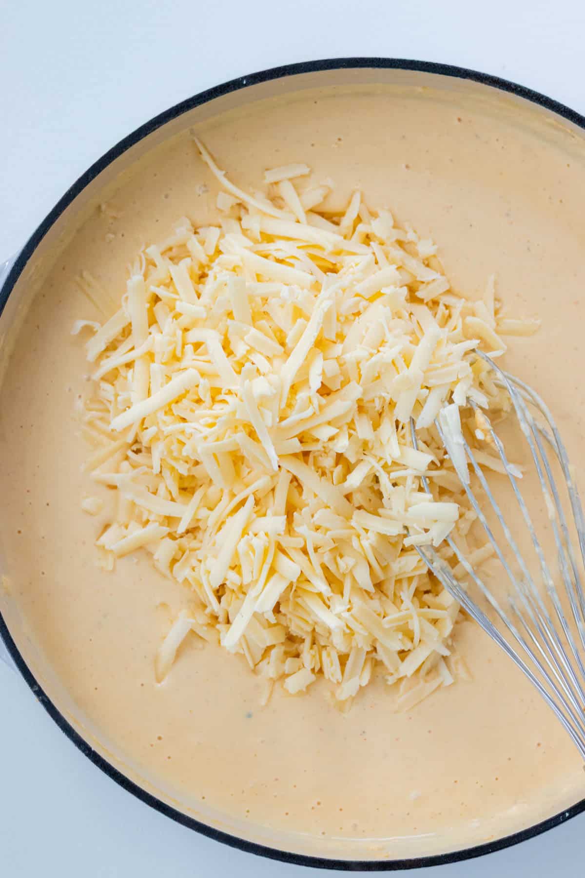 Adding the cheeses to the sauce base.