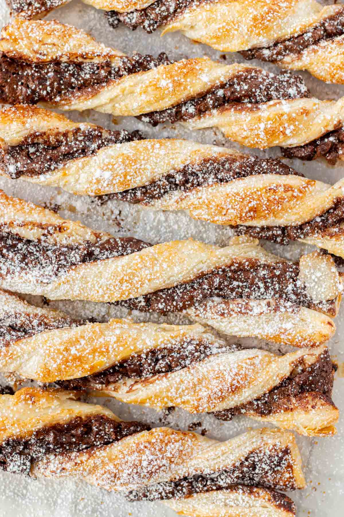 Sprinkling the chocolate twists with powdered sugar.
