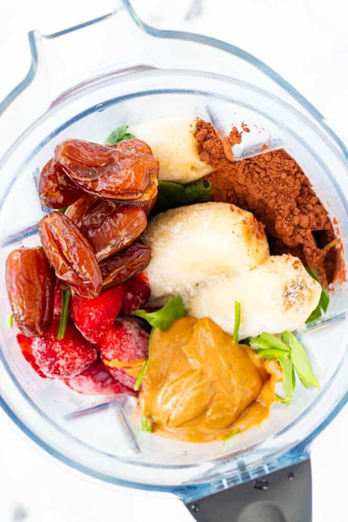 All of the ingredients for the smoothie piled into a blender.