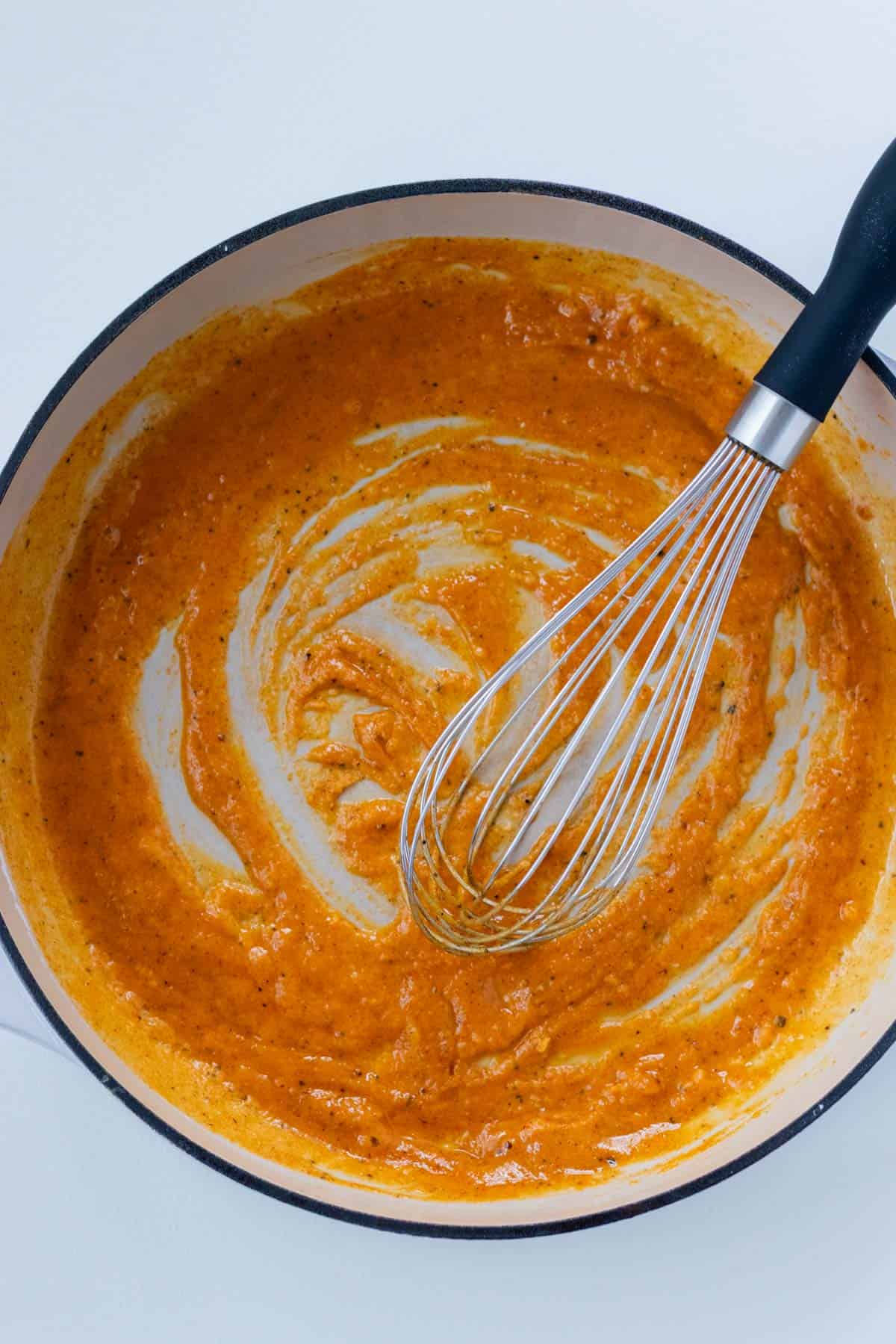 Adding the spices and flour to melted butter to make a roux.