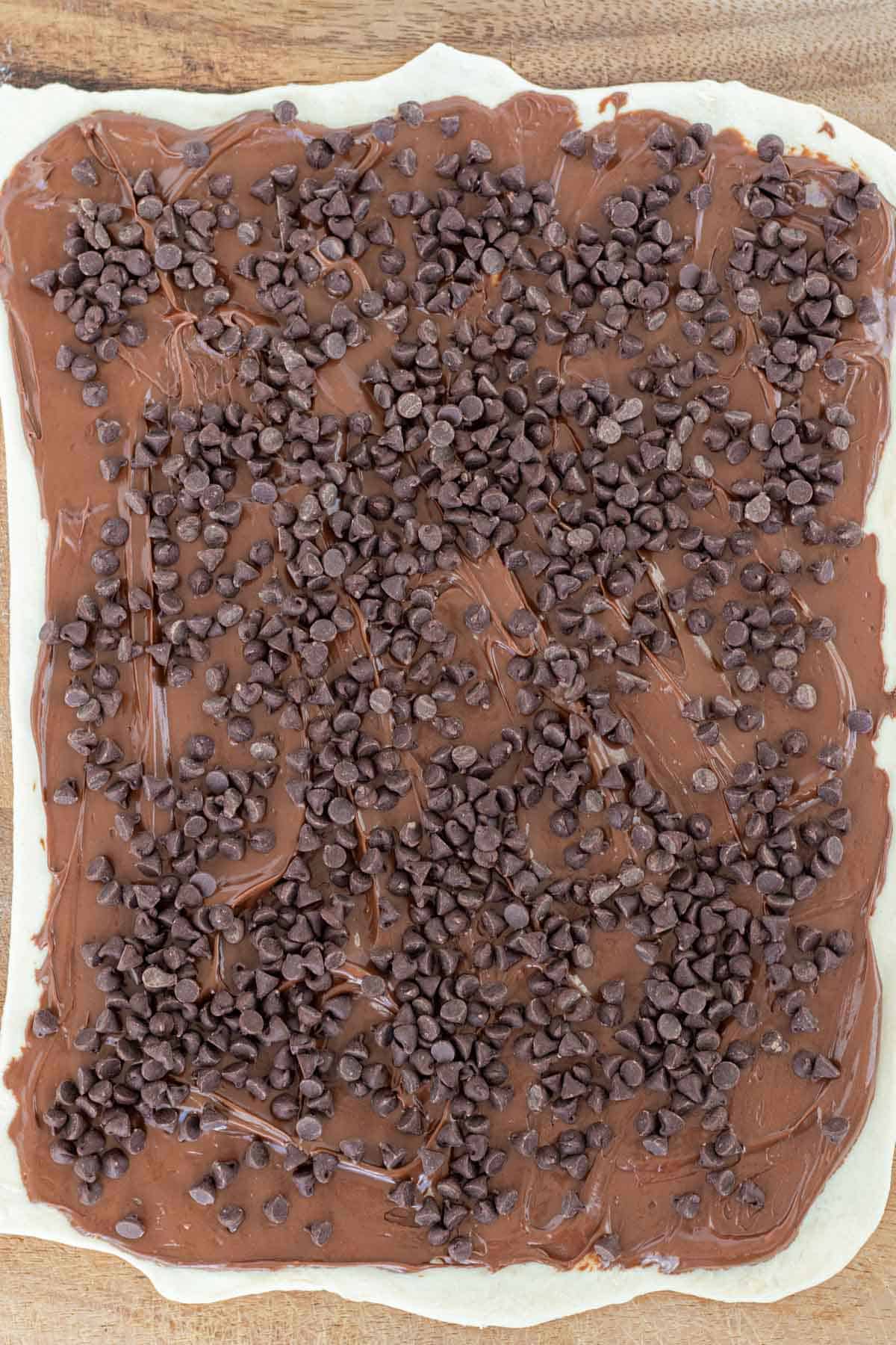 Puff pastry rolled out, covered in Nutella and mini chocolate chips.