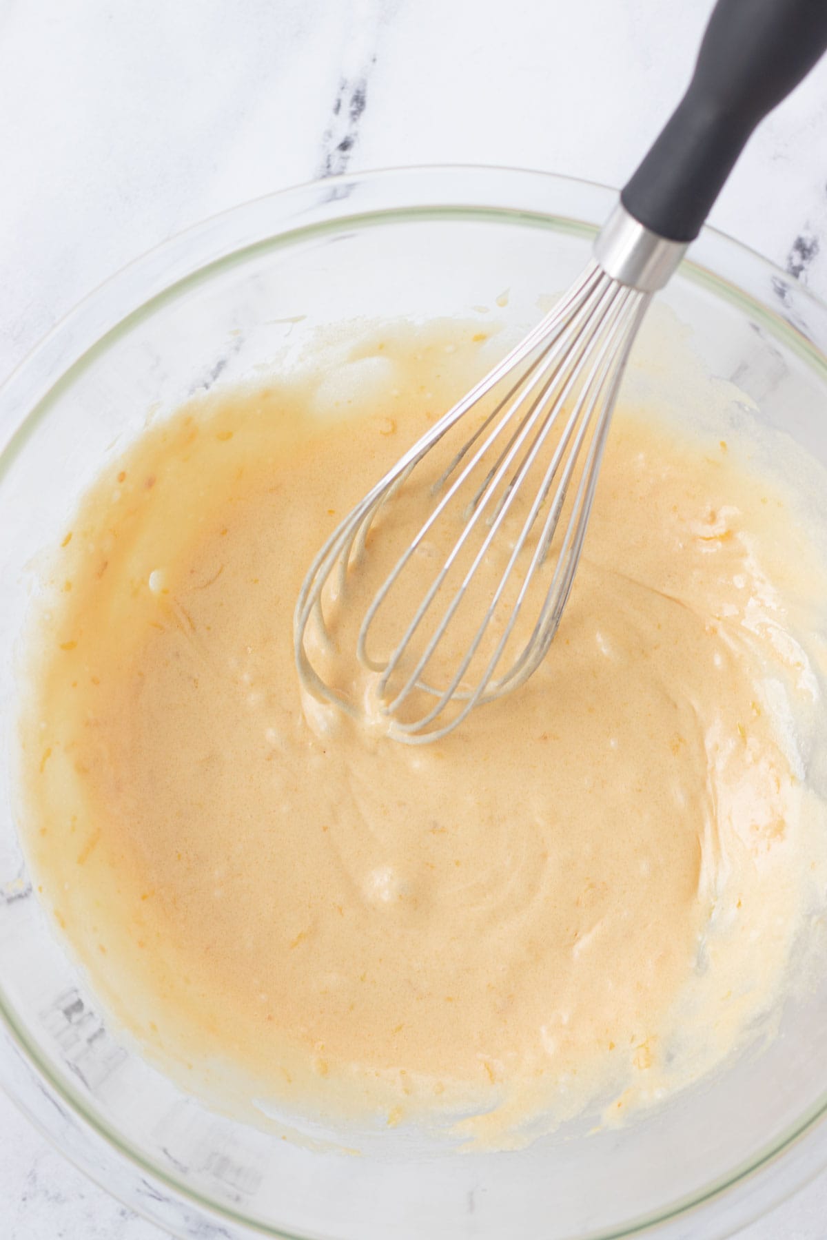 Combining the sugar, butter, lemon zest, lemon extract and eggs in a mixing bowl.