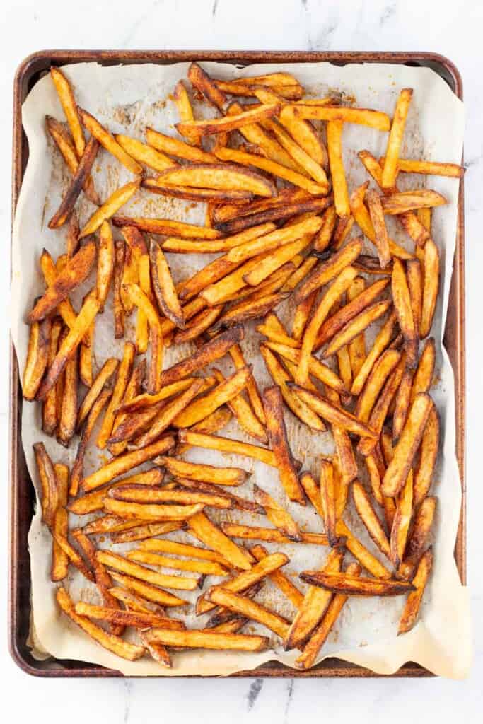 A baking sheet full of homemade baked fries.
