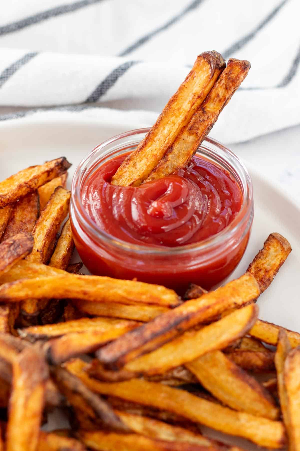 Dipping two french fries in ketchup.