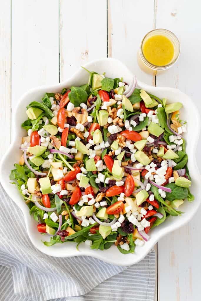 Layering all of the salad ingredients in a large serving dish.