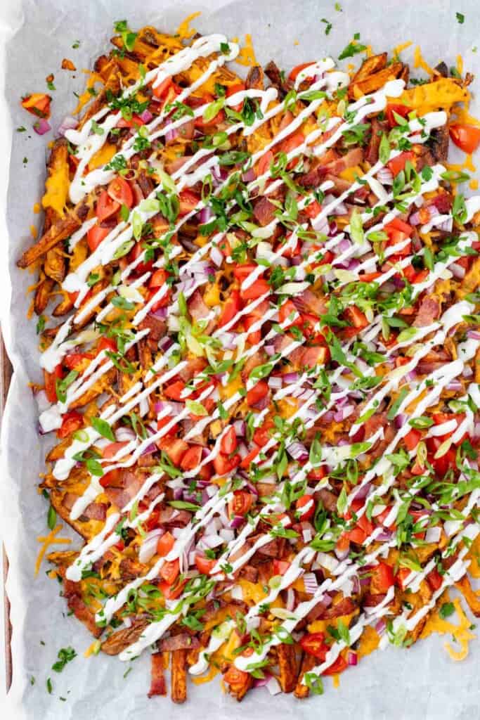 Adding a sour cream drizzle over top of the whole tray of loaded fries.