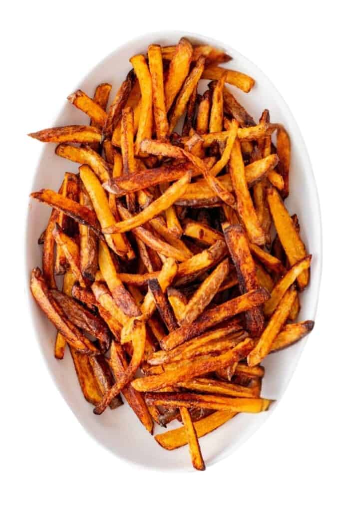 A white serving plate filled with baked french fries.