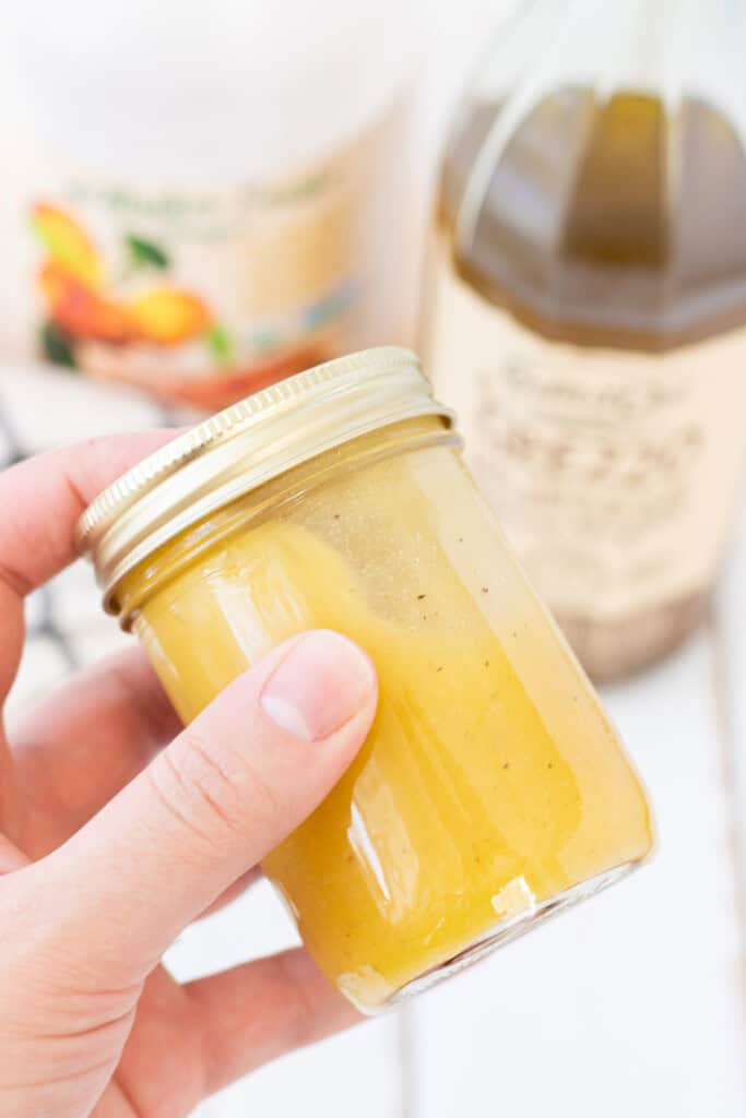 Shaking the mason jar to mix the dressing.