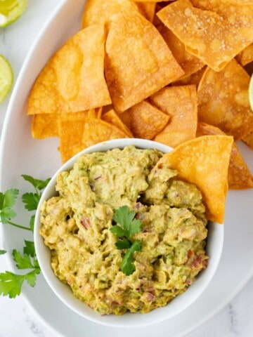 Dipping a corn tortilla chip in fresh guacamole.